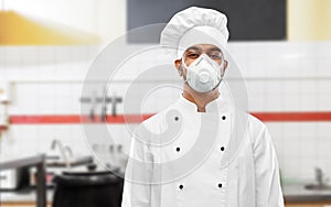 Male chef in respirator at restaurant kitchen