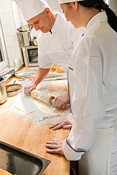 Male chef rolling dough with rolling pin