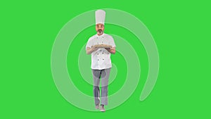 Male chef running and holding a pizza on a Green Screen, Chroma Key.