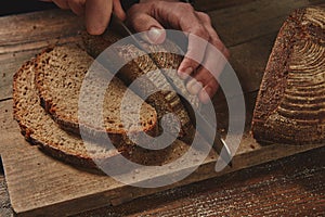 Male chef`s hand cutting Rye bread