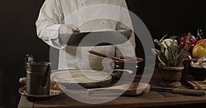 Male chef in white uniform holding a frying pan, sautÃ©ing spaghetti with fresh vegetables