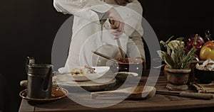 Male chef in white uniform prepares spaghetti with vegetables on the dish