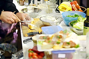 Male chefs hands make delicious sandwich on table