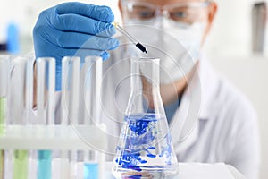 A male chemist holds test tube of glass