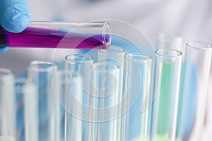 A male chemist holds test tube of glass