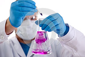 A male chemist holds test tube of glass