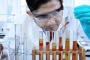 Male chemist pouring chemical fluid