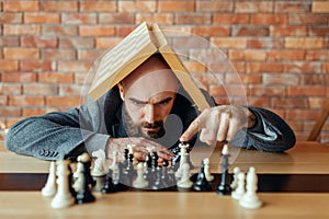 Male chess player with board on his head