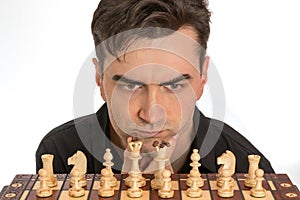 Male chess player contemplating his first move in front of white background