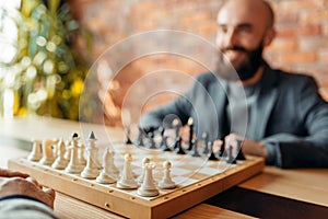 Male chess players, focus on board with figures