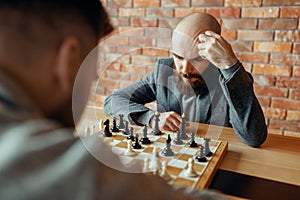 Male chess players playing, thinking process