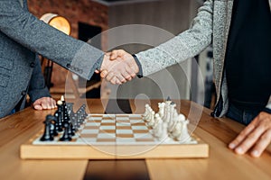 Male chess players shake hands before the game