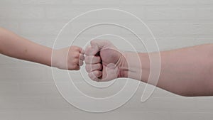 Male and children`s fist. Children`s fist beat on the fist of his father.