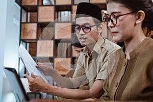 male civil servants in uniform sit holding worksheets next to female civil servants