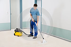 Male Cleaner Vacuuming Floor