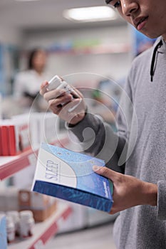 Male client examining sleeping pills box