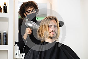 Male client getting haircut by black hairdresser