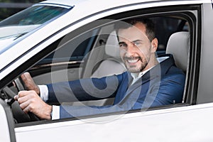 Male client testing new car, looking on camera