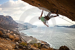 Male climber climbing overhanging rock photo