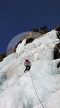 Male climber on a frozen waterfall near Pontresina in the Swiss Alps