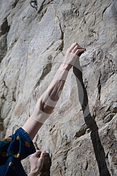 Male climber hand grip rock face looking down