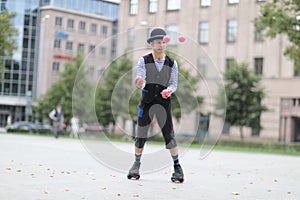 A male clown juggles with red balls