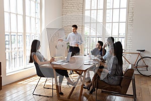 Male coach make whiteboard office presentation to diverse employees