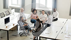 Male coach mentor speaking at corporate group meeting, top view