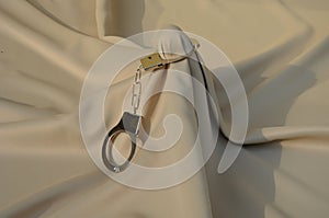 Male cock under a satin sheet in bed. it is a gift for a partner bought in a sex shop. the picker or dildo is tastefully arranged photo