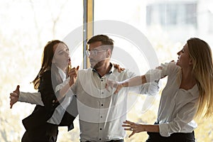 Male colleague set apart aggressive business women fighting in office