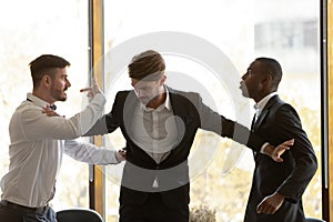 Male colleague set apart angry diverse businessmen fighting in office