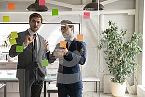 Male colleagues brainstorm develop business plan in boardroom