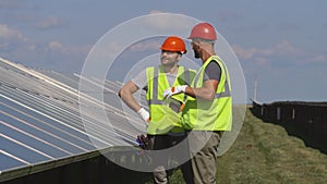 Male colleagues discussing solar panels