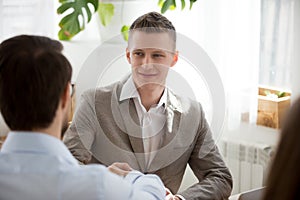 Male colleagues get acquainted handshaking at meeting