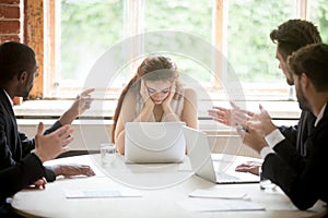 Male colleagues pointing fingers at upset female boss on meeting