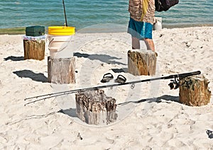 Male collecting fishing gear resting on wood pilings on a sandy, tropical beach on the Gulf of Mexico