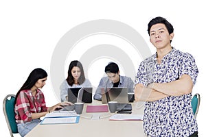 Male confident entrepreneur with his team on studio