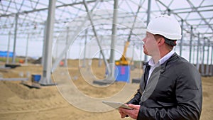 Male construction engineer architect supervisor in hard hats working checking quality using laptop, tablet computer in