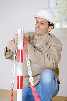 male construction worker erecting safety barrier