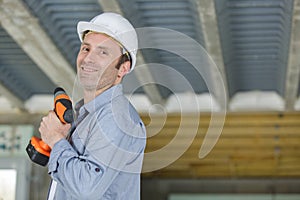 male construction worker holding cordless drill