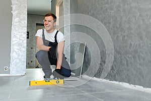 A male construction worker installs a large ceramic tile