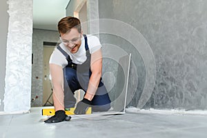 A male construction worker installs a large ceramic tile