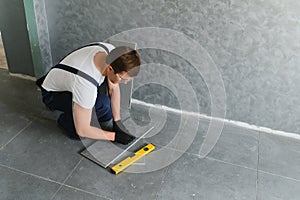 A male construction worker installs a large ceramic tile