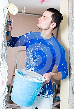 Male construction worker priming doorway