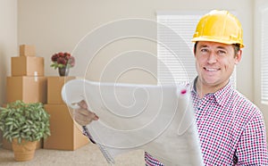 Male Construction Worker In Room With Boxes Holding Roll of Blue