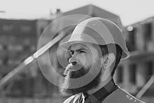 Male construction worker in work clothes and a construction helmet. Industrial theme. Young businessman construction