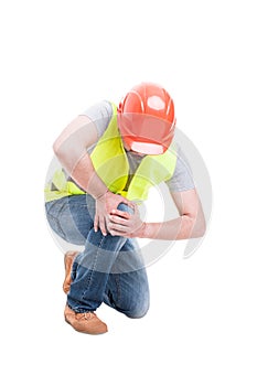 Male constructor kneeling and suffering from knee pain