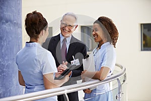 Male Consultant Meeting With Nurses Using Digital Tablet