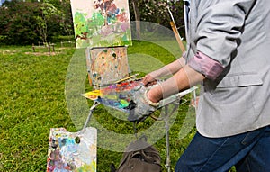 Male contemplative painter cleaning off his palette