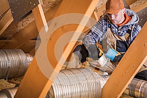 Male Contractor Binding Ventilation Pipes With Duct Tape photo